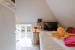 a large stuffed animal sitting on a bed in a room at Inselidyll Alter Friesenhof in Süderende