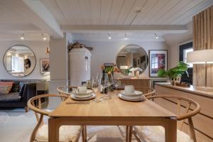 a dining room with a wooden table and chairs at Inselidyll Alter Friesenhof in Süderende
