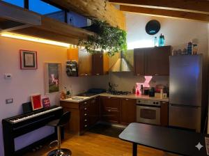 a kitchen with a stove and a piano in it at Casa di Leo in Morbegno
