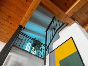 an open stairwell with a yellow sign on a wall at Casa di Leo in Morbegno +13 photos