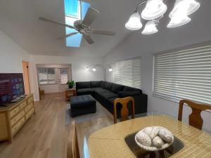 a living room with a black couch and a ceiling fan at Stylish budget friendly retreat! in Lake Placid