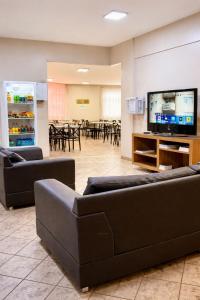 a waiting room with couches and a flat screen tv at Hotel Nacional Service - Fácil acesso a Região da 44 e Rodoviária in Goiânia