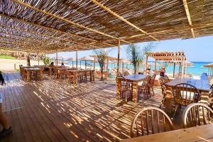 a wooden deck with tables and chairs on the beach at Halkidiki in Skala Fourkas