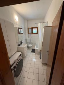 a white bathroom with a toilet and a sink at Halkidiki in Skala Fourkas +26 photos