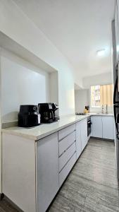 a kitchen with white cabinets and a counter top at Comodidades, modernidad, céntrico in Caracas