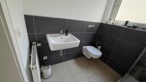 a bathroom with a sink and a toilet at Gästezimmer Kirrlach in Waghäusel +9 photos