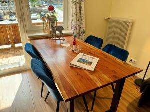 a wooden dining room table with blue chairs at Alpenlodge Ferienwohnung 5 in Thiersee