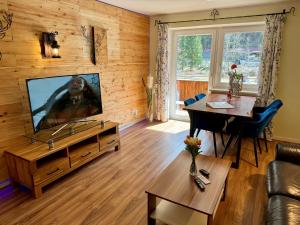 a living room with a flat screen tv on a wooden wall at Alpenlodge Ferienwohnung 5 in Thiersee +207 photos
