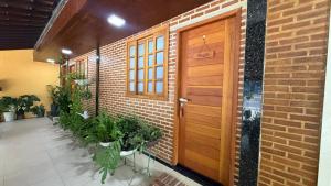 a brick building with a wooden door and plants at Caminho de Itacoatiara in Niterói