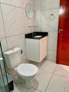 a bathroom with a white toilet and a mirror at Refúgio do Mar in Nísia Floresta