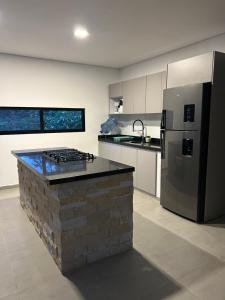 a kitchen with a stone counter and a refrigerator at Dalusa House in Tena