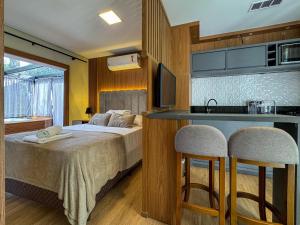 a bedroom with a bed and two bar stools at Studios Heaven in Gramado
