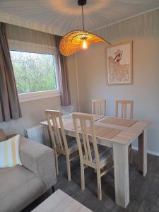 a dining room with a wooden table and chairs at de Schelphoeve in Ellemeet