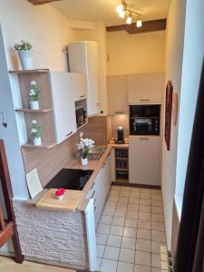 a small kitchen with white cabinets and a refrigerator at Chez Lisette Honfleur 500m plage in Honfleur