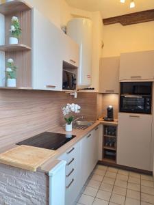 a kitchen with white cabinets and a counter top at Chez Lisette Honfleur 500m plage in Honfleur