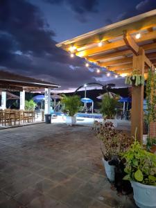 a patio with plants and lights at night at Pousada irmãos Oliveira in Lindóia