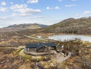 an aerial view of a house on a hill with a lake at Hytte med peis utsikt & lakseelv rett nedenfor! in Lødingen