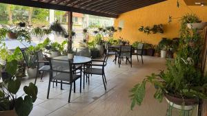 a patio with tables and chairs and potted plants at Caminho de Itacoatiara in Niterói +5 photos