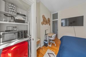 a small room with a bed and a microwave at Times Square Retreat with Private Bathroom and Kitchenette in New York
