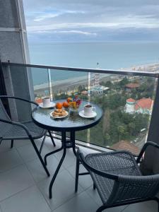 a table with a plate of fruit on a balcony at TOWERS Apartament in Batumi