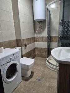 a bathroom with a toilet a sink and a washing machine at TOWERS Apartament in Batumi +9 photos