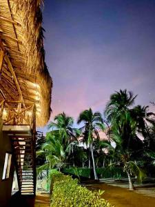 a view of a beach with palm trees and a building at Cabaña CasaMar Angelica in El Puertón +13 photos