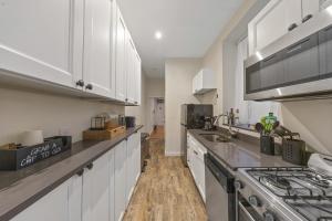 a kitchen with white cabinets and a stove top oven at Steps from Times Square - Cozy Room - Shared Bath in New York