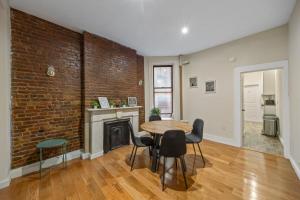 a living room with a brick wall and a table and chairs at Steps from Times Square - Cozy Room - Shared Bath in New York