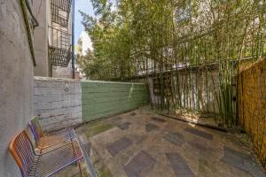 a chair sitting on a patio next to a fence at Steps from Times Square - Cozy Room - Shared Bath in New York