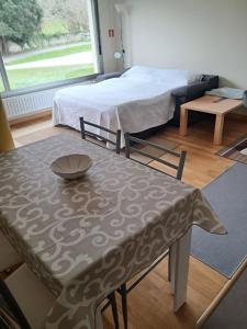 a living room with a table and a bed and a room at Calle Clemente Hernando Balmori nº7 in Llanes