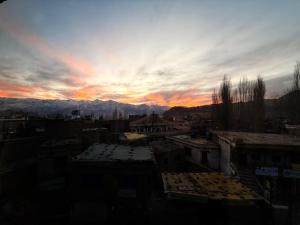 a sunset over a city with buildings and mountains at Cho Suites in Leh