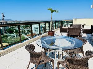 a table and chairs on a balcony with a view at Flat Itaborai · Toque a campainha A908 Flat Luxo completo Centro in Itaboraí