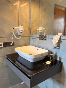 a white sink on a black counter in a bathroom at Cho Suites in Leh +10 photos