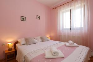 a bedroom with a bed with towels on it at Apartment Tea with Sea View in Petrcane