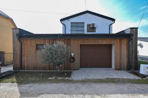 a house with a garage with a tree in front of it at Villa OLIVA in Kľačany