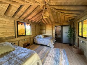 a bedroom with two beds in a wooden cabin at Villas Julieta in El Peñol