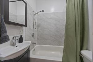 a bathroom with a sink and a shower with a shower curtain at Private Room at a Shared Apartment by Times Square in New York