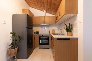 a kitchen with a stainless steel refrigerator and wooden cabinets at Αυλή στην Μαρίνα in Kalamata +26 photos