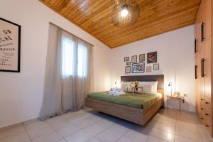 a bedroom with a bed with a wooden ceiling and a window at Αυλή στην Μαρίνα in Kalamata