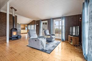 a living room with two couches and a tv at Hytte med peis utsikt & lakseelv rett nedenfor! in Lødingen