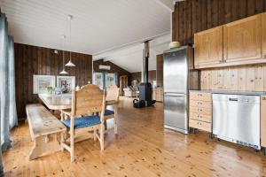 a kitchen and dining room with a table and a refrigerator at Hytte med peis utsikt & lakseelv rett nedenfor! in Lødingen +11 photos