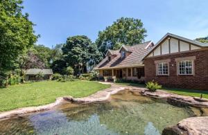 a house with a pond in the yard at Foundry farmhouse in Bothaʼs Hill