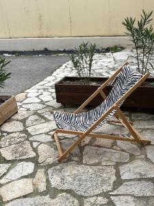 a zebra print chair sitting on a stone ground at La maisonnette LMV in Sanary-sur-Mer