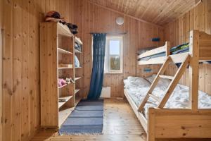 a room with two bunk beds and a window at Hytte med peis utsikt & lakseelv rett nedenfor! in Lødingen