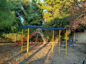 a playground with a red and blue swing at Villa Estrella - Pool - Sunset Views - 200m Siviri Beach in Siviri