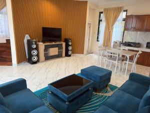 a living room with a couch and a table with a tv at Eton Asia Villas-Kota Bunga in Puncak