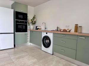 a kitchen with a washing machine and a refrigerator at Appartement Mango in Rivière-Salée
