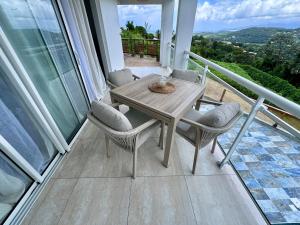 a table and chairs on the balcony of a house at Appartement Mango in Rivière-Salée