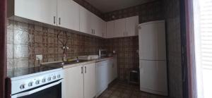 a kitchen with white cabinets and a white refrigerator at Bar Central Point - 2BR Apartment in Bar