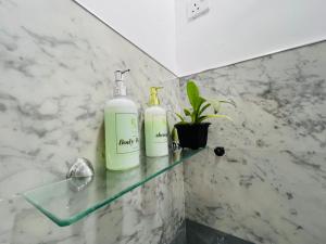 two bottles sitting on a glass shelf in a bathroom at Rich Grove Inn in Ella +107 photos